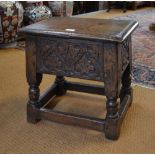 A 17th century style joint oak stool with hinged seat enclosing storage well raised over foliate