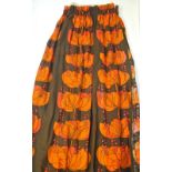 A 1970s pair of lined curtains with an iconic bright orange/pink flower design on a brown ground,