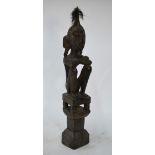 An African tribal carved wood seated figure with hair top-knot,