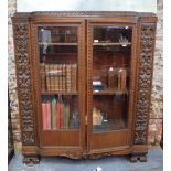 An Art Deco period heavily carved bookcase in the Flemish style,