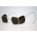 A pair of Victorian smoked glass spectacles with folding side-lenses and gilt frames,
