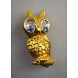 An 18ct yellow gold owl brooch with sapphire and diamond eyes, realistically textured,