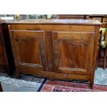 A French antique fruitwood cupboard having a pair of panelled doors,