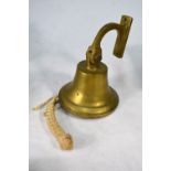 A small brass maritime bell with knotwork pull