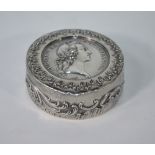 A French circular white metal snuff box, the hinged cover inset with a 1745 Louis XV medallion,