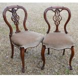 A pair of Victorian rosewood salon side chairs with serpentine form overstuffed seats (2)