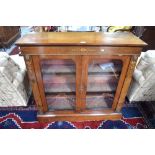 A Victorian satinwood inlaid ormolu mounted walnut cabinet having a pair of arched glazed panel