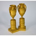 A pair of 19th century gilt metal classical urns on column bases,
