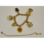 A yellow gold curb bracelet with padlock, 9ct having various charms attached, mostly gold,