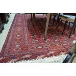 An old Afghan Turkoman carpet, the red ground with five rows of stylised guls,