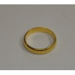 A yellow metal D-shaped wedding band stamped 18ct approx 2.