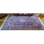 An antique Persian Kashan rug, the centre medallion design on blue/red ground,