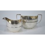 An Edwardian silver oval milk and sugar pair with floral-moulded rims, Haseler Brothers,