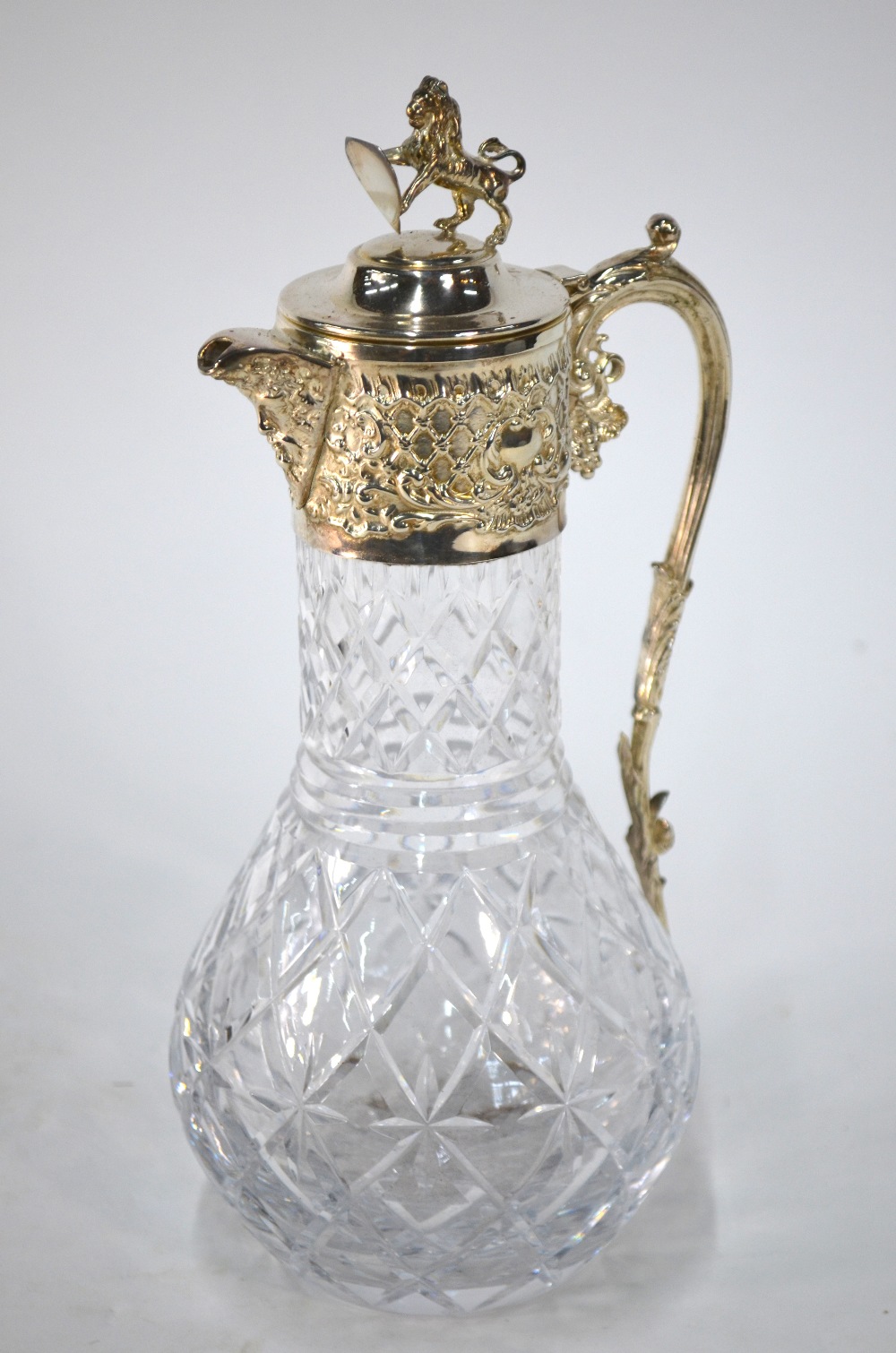 A cut glass claret jug with electroplated collar,