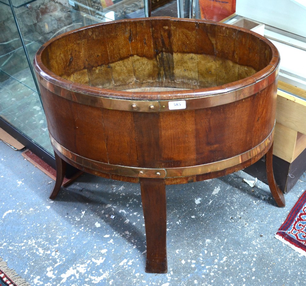 A brass bound coopered mahogany planter of ovoid form, raised on four through-staves,