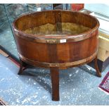 A brass bound coopered mahogany planter of ovoid form, raised on four through-staves,