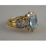An aquamarine and diamond oval cluster ring having pierced diamond set shoulders,