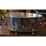 A large oval electroplated twin-handled champagne bath on pad feet,