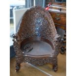 A substantial padouk, or other, wood armchair with reticulated sides and back,
