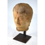 An antique carved stone head 'Le Sourire