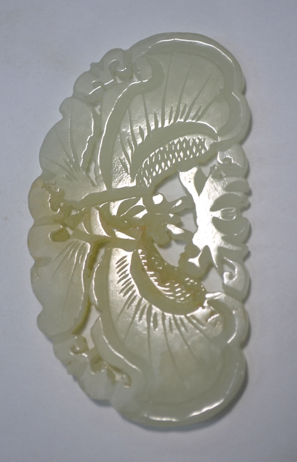 A Chinese small green jade applique or other ornament of mottled white hue,