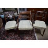 A set of five Regency mahogany side chairs with over-stuffed seats, raised on sabre front legs,