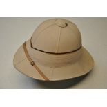 A vintage pith helmet retailed by Gieves Royal Naval Outfitters, 21 Old Bond St.