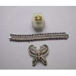 A decorative linked bracelet set with white paste fern style links between two rows of purple paste
