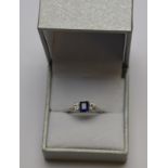 A rectangular sapphire and brilliant cut diamond three stone ring in white metal claw setting