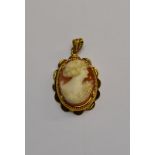 A shell cameo pendant of female in yellow metal mount,