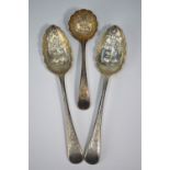 A pair of Edwardian silver berry spoons with chased bowls and engraved stems to/w a matching sifter