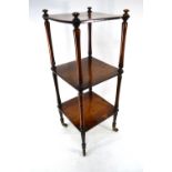 A Victorian rosewood three tier what-not raised on turned supports to brass castors,