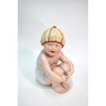 A large Gebruda Heubach bisque 'Piano Baby', the smiling seated child wearing a mop hat and nappy,