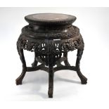A Chinese wood and marble (or other stone) stand of typical cylindrical and reticulated form,