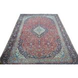 An old Persian Kashan carpet, traditional centre medallion design on pale blue/red ground,