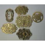 A collection of five ornate buckles to/w Chinese character brooch