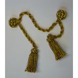 A gilt metal cloak clasp comprising rope chain with tassel terminations suspended from two circular