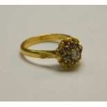 A ruby and diamond cluster ring in partly textured yellow metal setting stamped 18ct