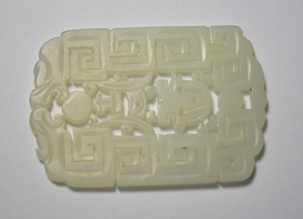 A Chinese green jade pendant of whitish hue,