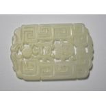 A Chinese green jade pendant of whitish hue,