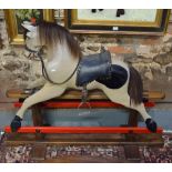 A Victorian style painted wood rocking horse with natural hair mane and tail, on stained pine stand,