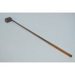 An unusual antique golf putter with lead-weighted wooden block head and hickory shaft with leather