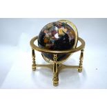A black enamelled table globe, inset with wire cloissonnes, polished hardstones and mother-of-pearl,
