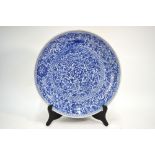 A Chinese large and heavily potted blue and white dish, decorated with dense floral designs,