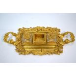 A 19th century French Rococo revival ormolu inkstand with heavy cast foliate and scroll rim and