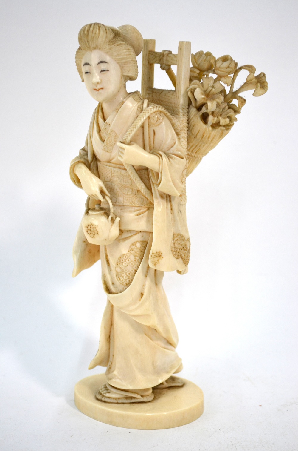 A Japanese ivory Okimono, carved as a Yamato Nadeshkom wearing zori,