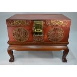A Chinese old red lacquered trunk with shou or other motifs and a gilt metal lock and fitting,