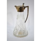 An Edwardian cut and moulded glass claret jug with writhen flared base and silver collar,