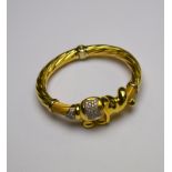 A yellow metal twisted torque-style bangle having snap modelled as an elephant,
