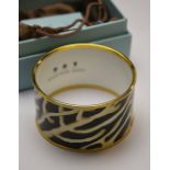 A Halcyon Days gilt metal and cream and black organic design enamel bangle, 4 cm x 6.